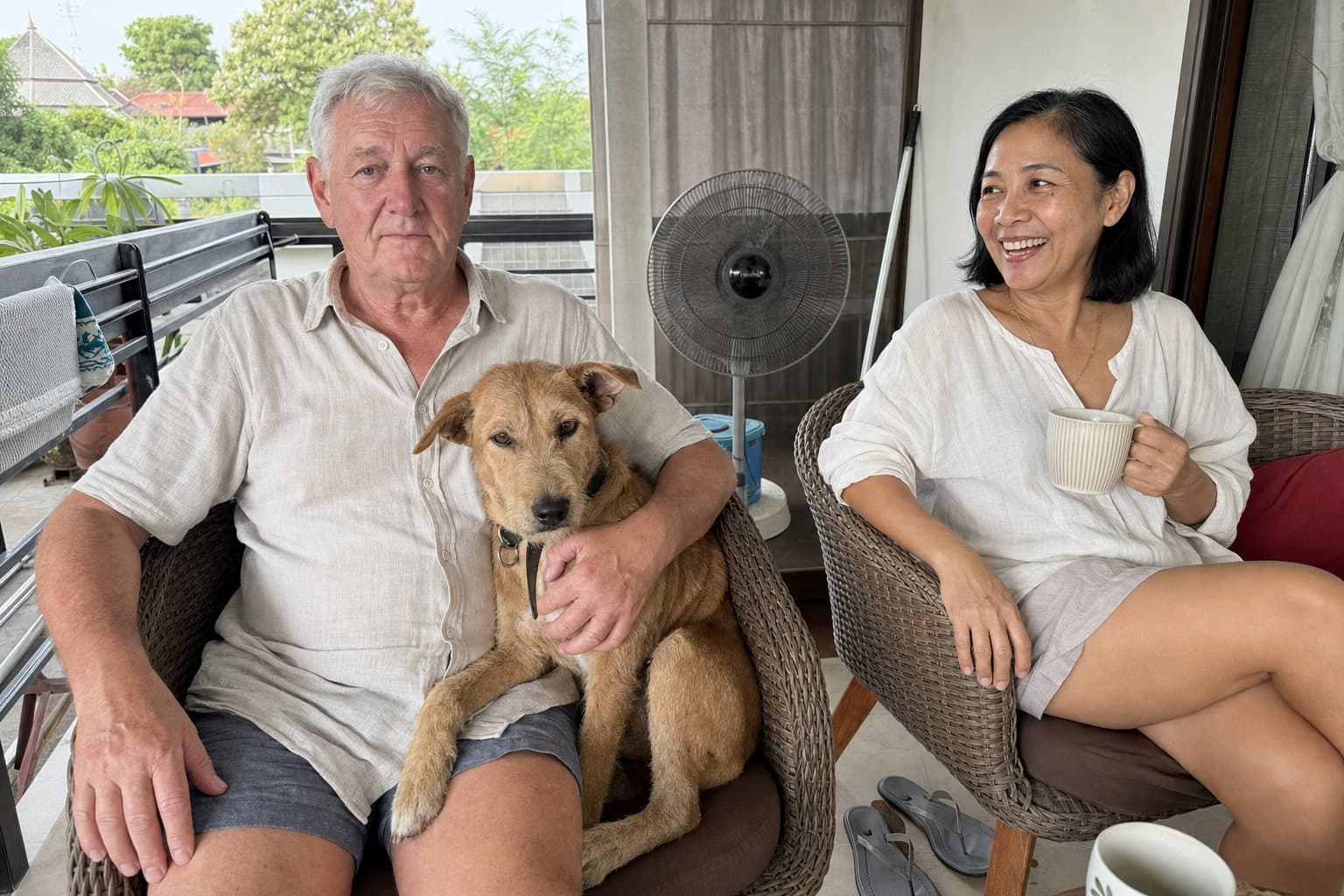 Tim with Biscuit the adopted soi dog, Nok laughing